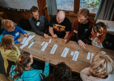 Een verzameling beelden van deelnemers en begeleiders die samen plezier maken, leren en nieuwe ervaringen opdoen tijdens kampactiviteiten in de buitenlucht.