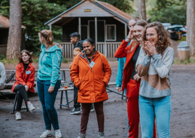 Een verzameling beelden van deelnemers en begeleiders die samen plezier maken, leren en nieuwe ervaringen opdoen tijdens kampactiviteiten in de buitenlucht.