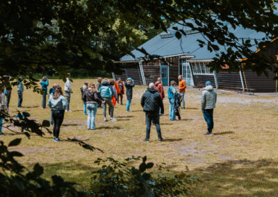Een verzameling beelden van deelnemers en begeleiders die samen plezier maken, leren en nieuwe ervaringen opdoen tijdens kampactiviteiten in de buitenlucht.