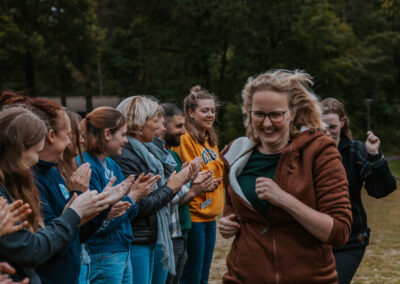 Een verzameling beelden van deelnemers en begeleiders die samen plezier maken, leren en nieuwe ervaringen opdoen tijdens kampactiviteiten in de buitenlucht.